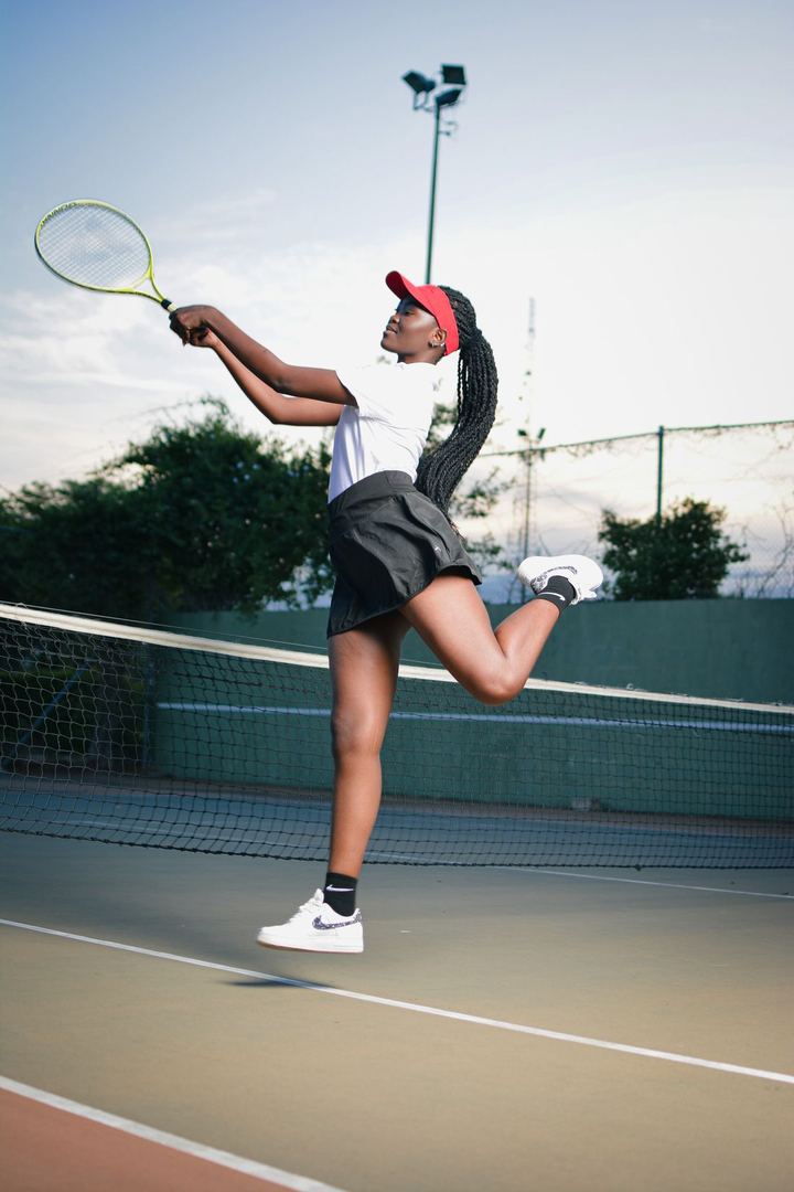A tennis player mid-serve at golden hour